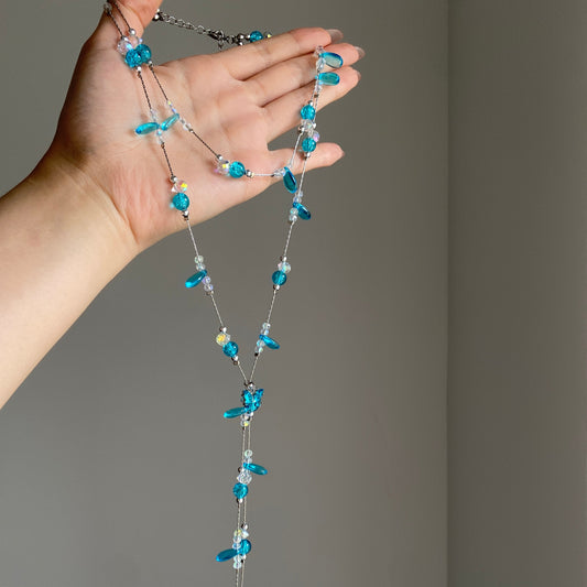 Aqua beaded layered lariat necklace with silver-tone chains and cascading blue strands