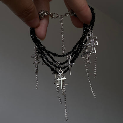 Black crystal cross tassel bracelet with layered bead strands and silver-tone charms