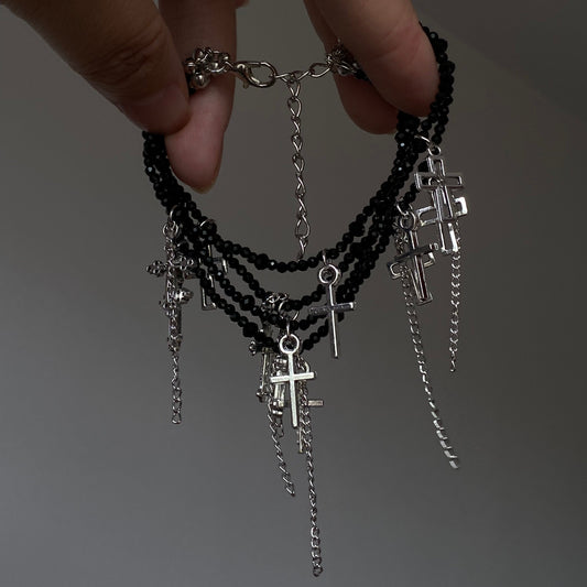 Black crystal cross tassel bracelet with layered bead strands and silver-tone charms