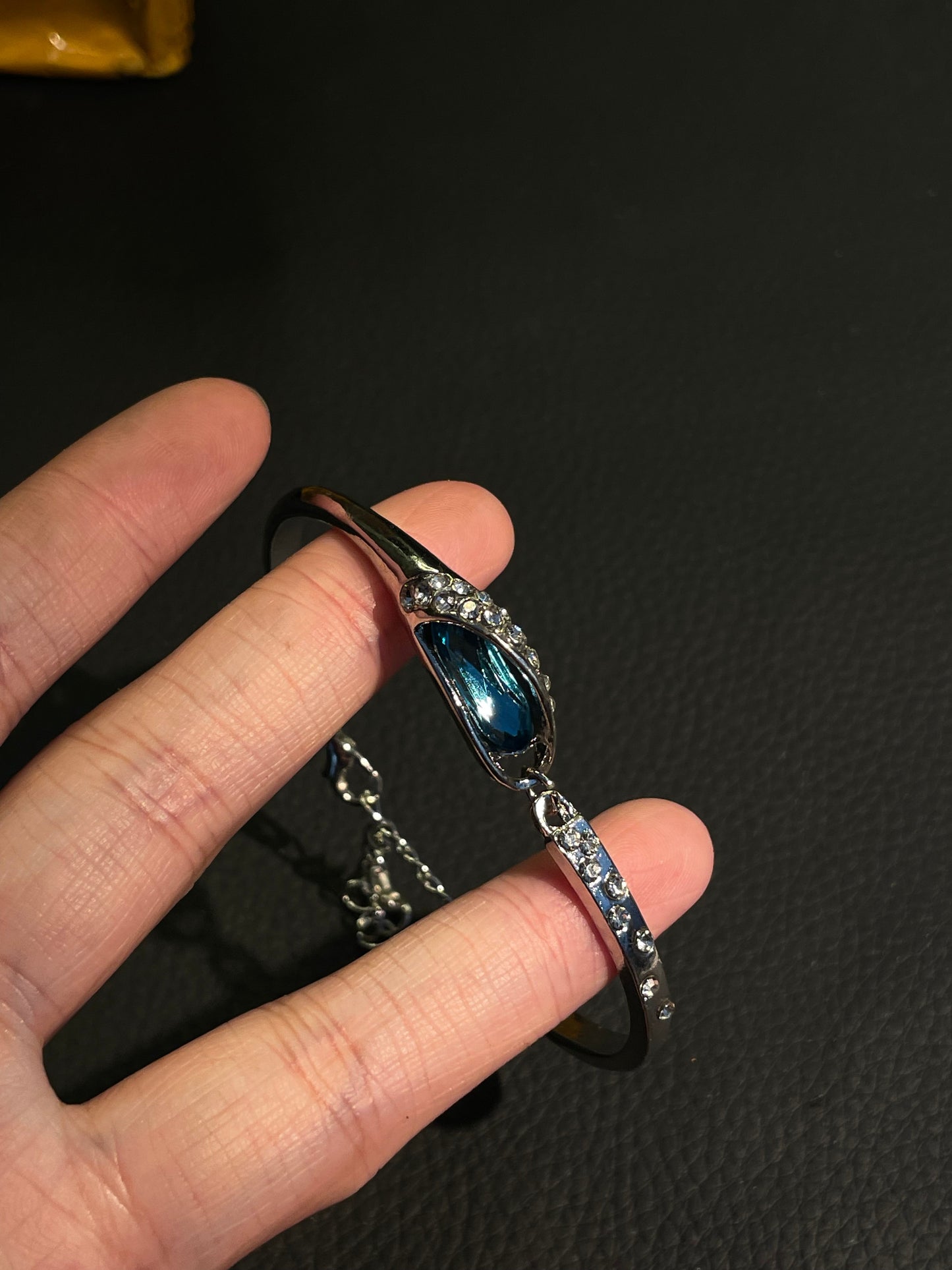 Vintage blue teardrop bangle with aqua crystal centerpiece and polished metal shine