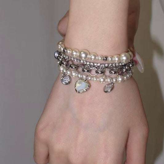 Faux pearl heart layered bracelet with silver-tone chains, zircon sparkle, and dangling charms