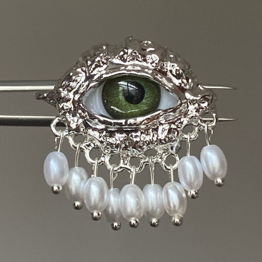 Green eye pearl fringe ring with silver-tone ornate frame and dangling pearl-style beads