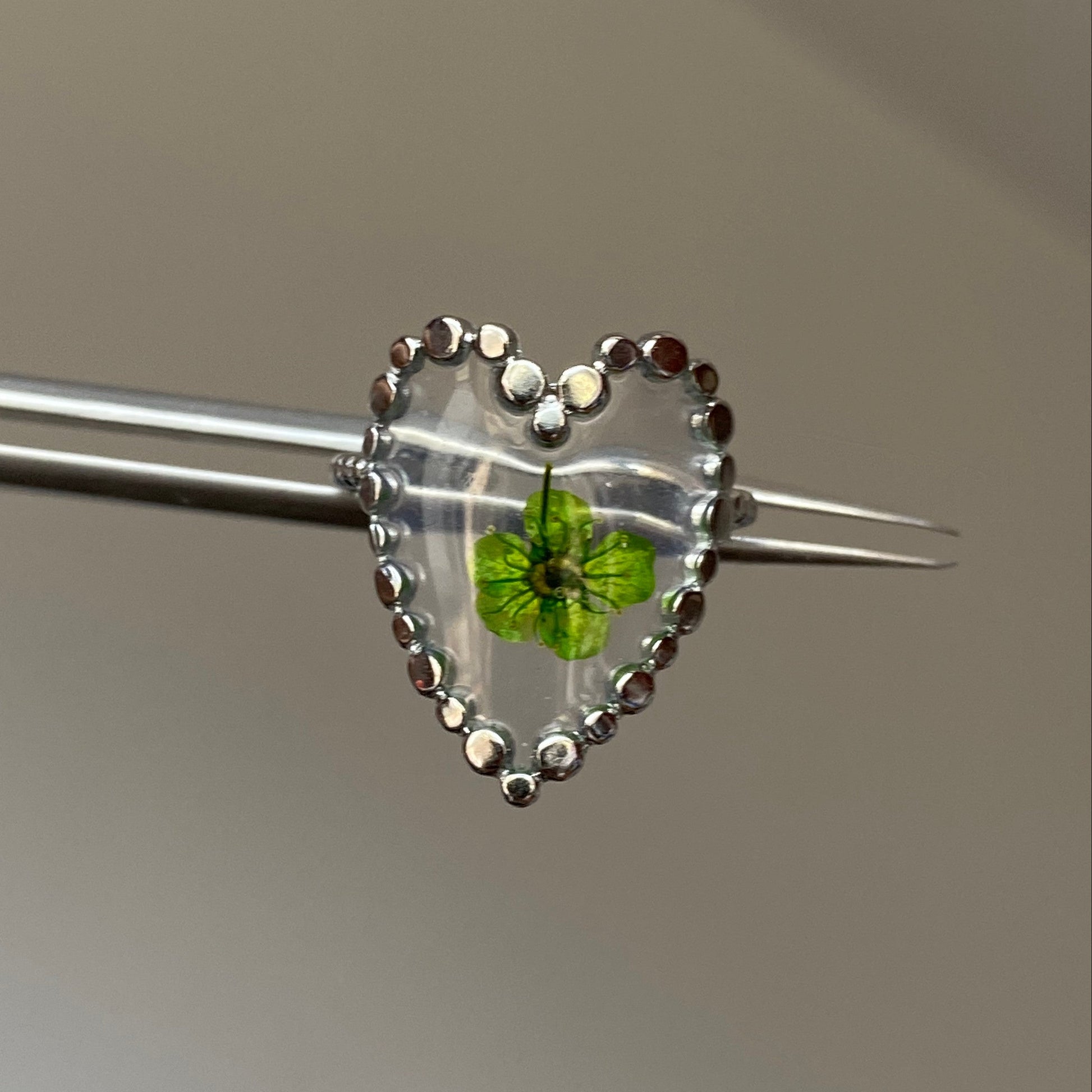 Green flower resin heart ring with clear centerpiece and silver-tone beaded edge