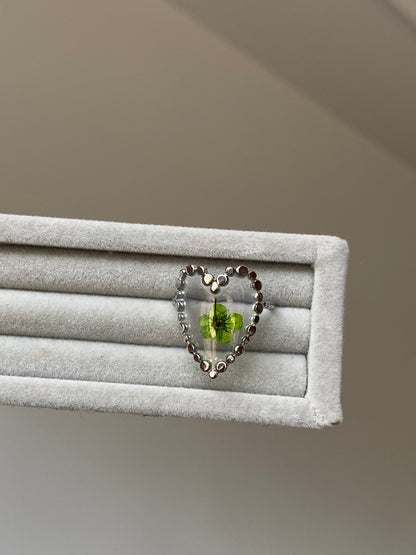 Clear heart flower ring with green floral detail inside a glossy resin-style heart