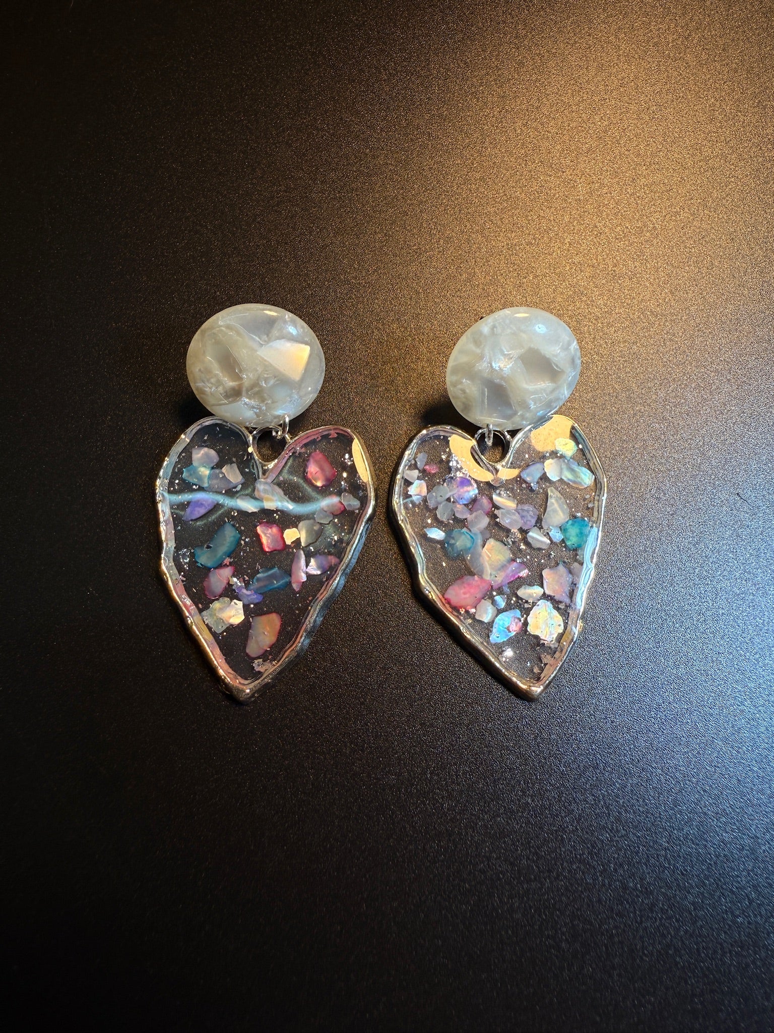 Holographic clear heart earrings with colorful confetti-like details inside
