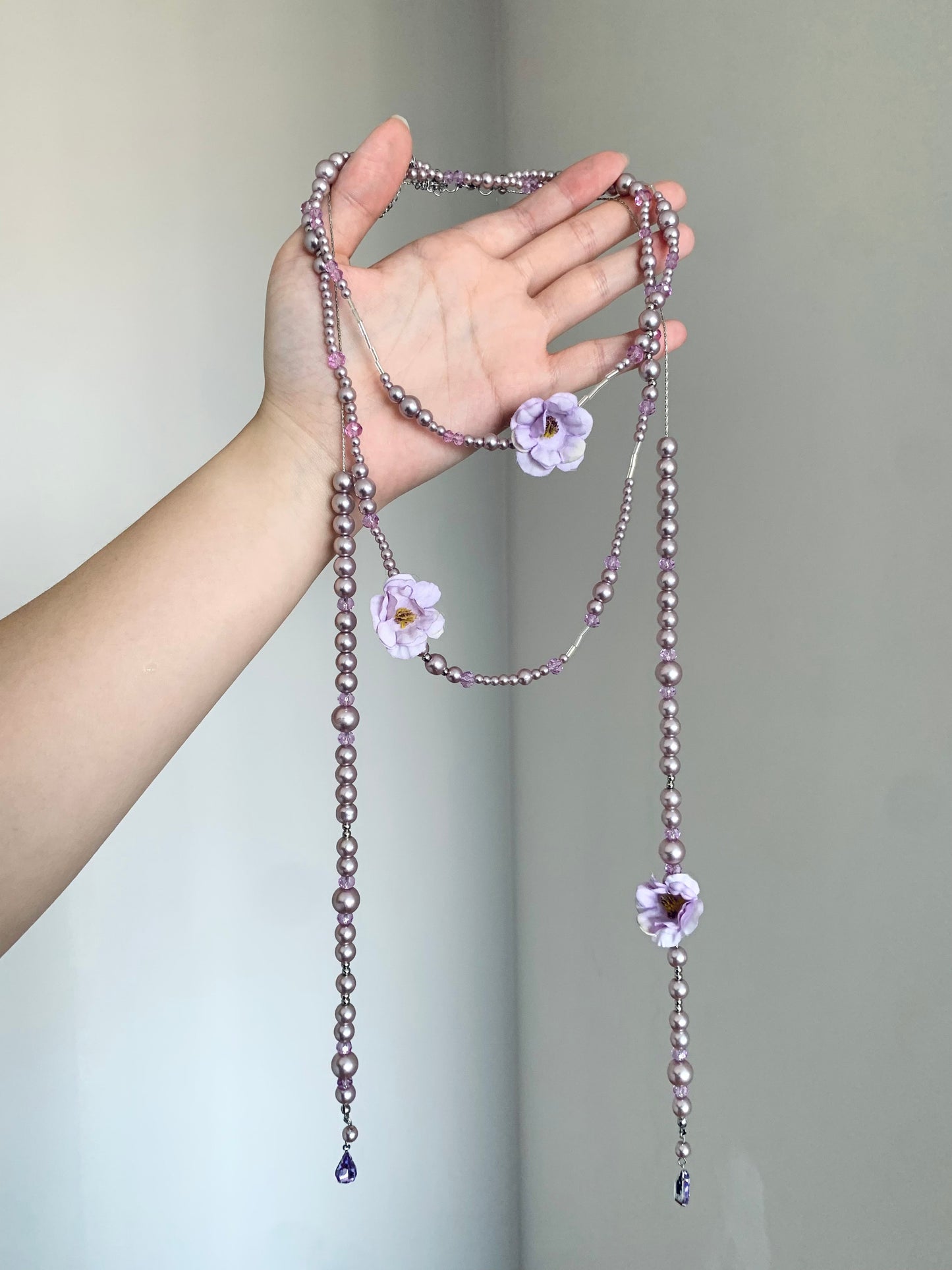 Purple beaded flower necklace styled on display bust with fairycore Y2K mood