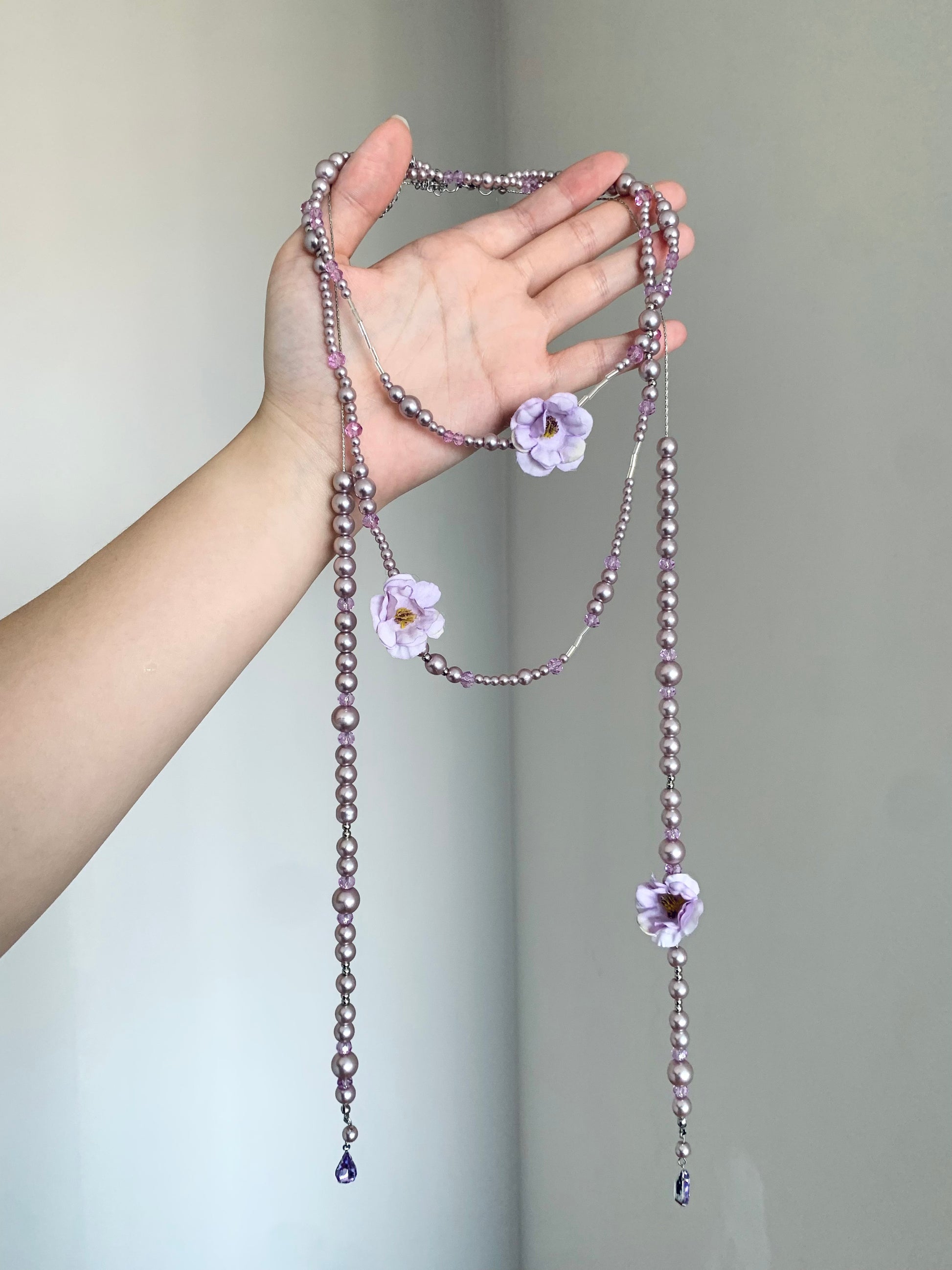 Purple beaded flower necklace styled on display bust with fairycore Y2K mood