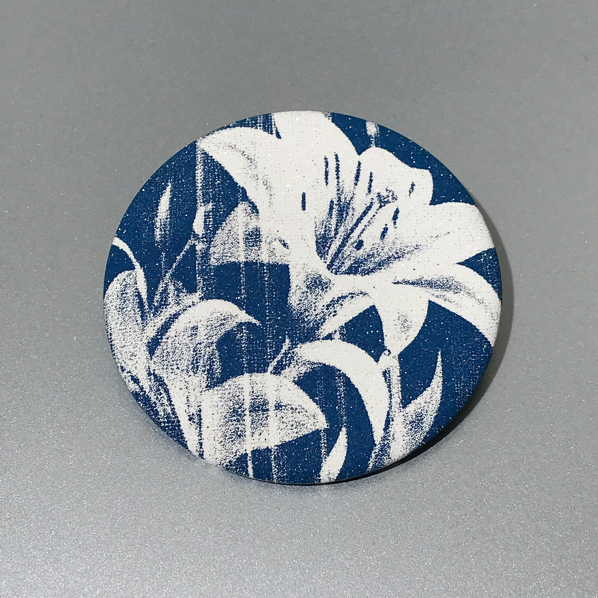 Round pocket mirror with dark blue floral artwork and matte-touch finish