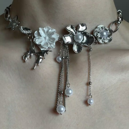 Close-up of silver-tone statement choker with pearl-style drops and chain tassels