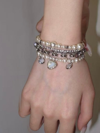 Y2K pearl chain bracelet with heart charm and layered silver-tone bracelet stack