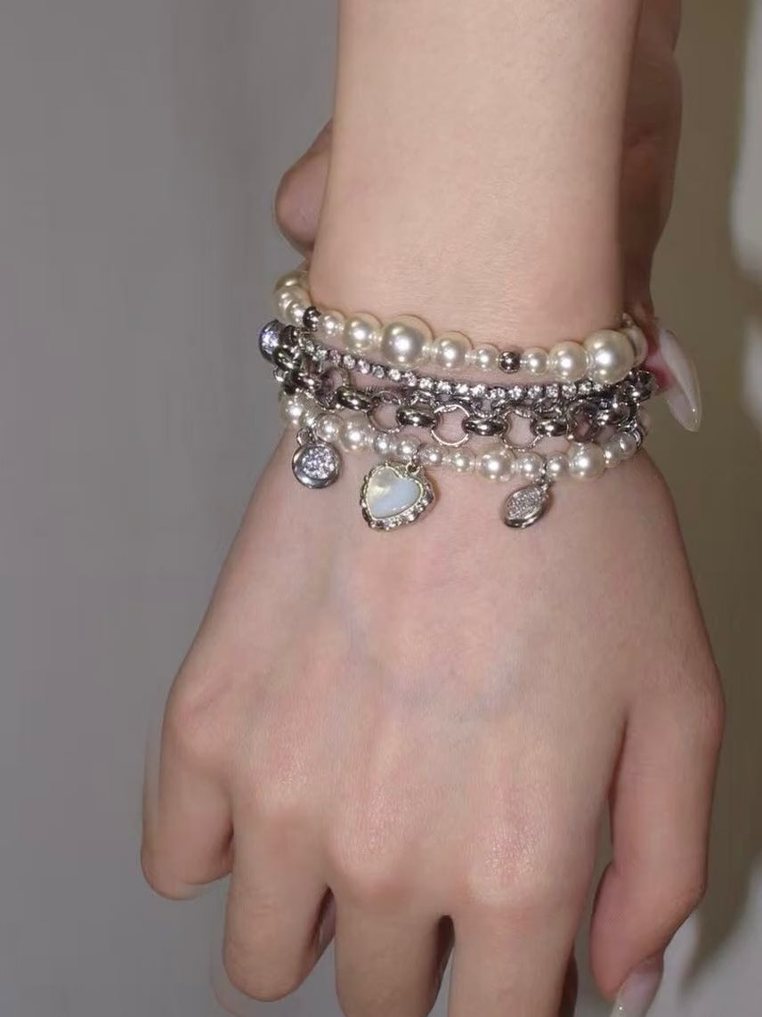 Y2K pearl chain bracelet with heart charm and layered silver-tone bracelet stack