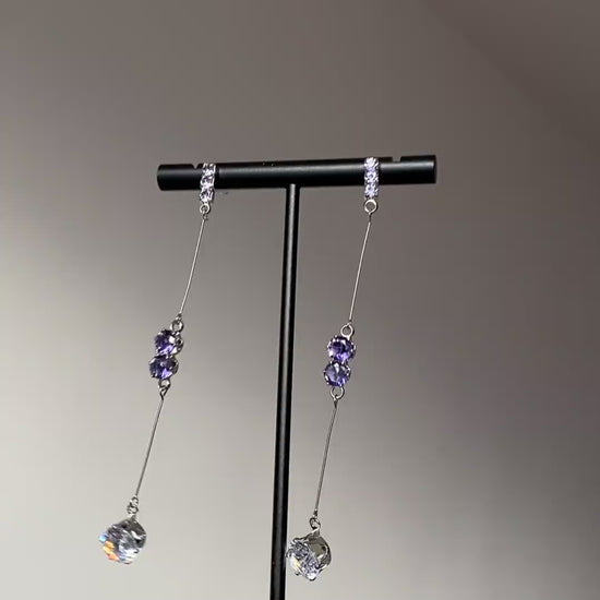 Clear teardrop crystal earrings with purple stones and silver-tone metal details