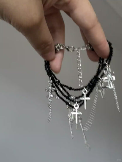 Silver cross tassel bracelet with black crystal-style beads and dark styling mood