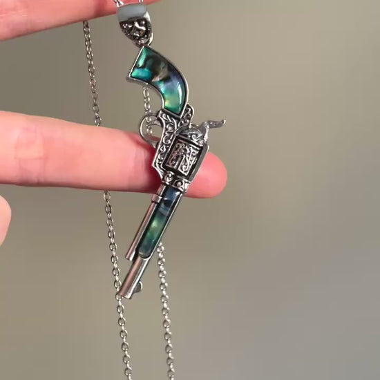 Silver-tone pistol pendant necklace with blue-green inlay and engraved details