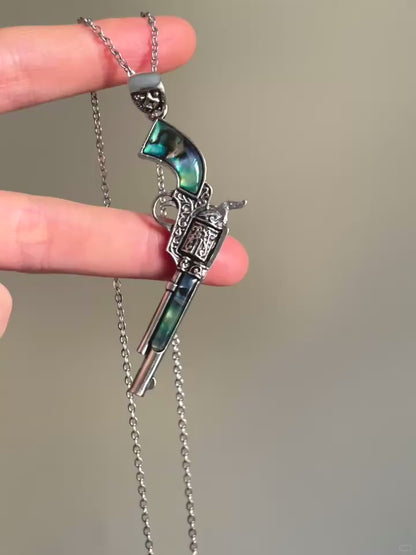 Silver-tone pistol pendant necklace with blue-green inlay and engraved details