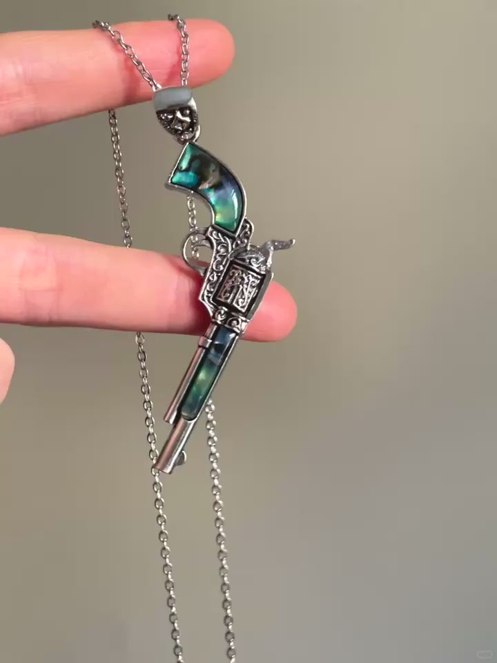 Silver-tone pistol pendant necklace with blue-green inlay and engraved details