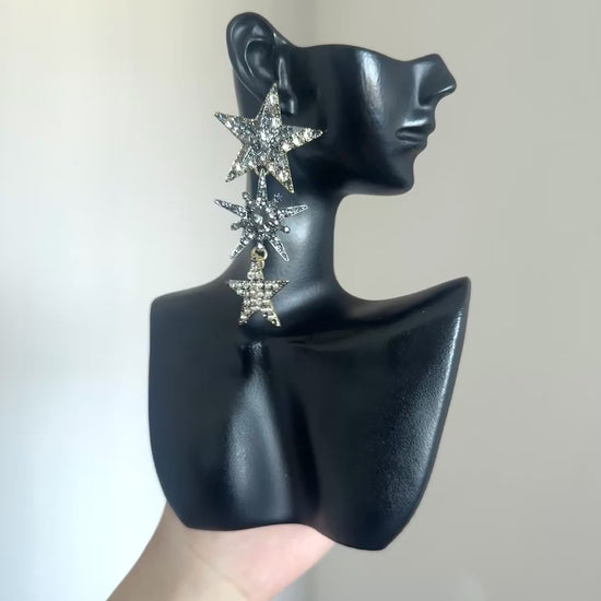 Celestial rhinestone earrings with layered star shapes and dramatic dangle design