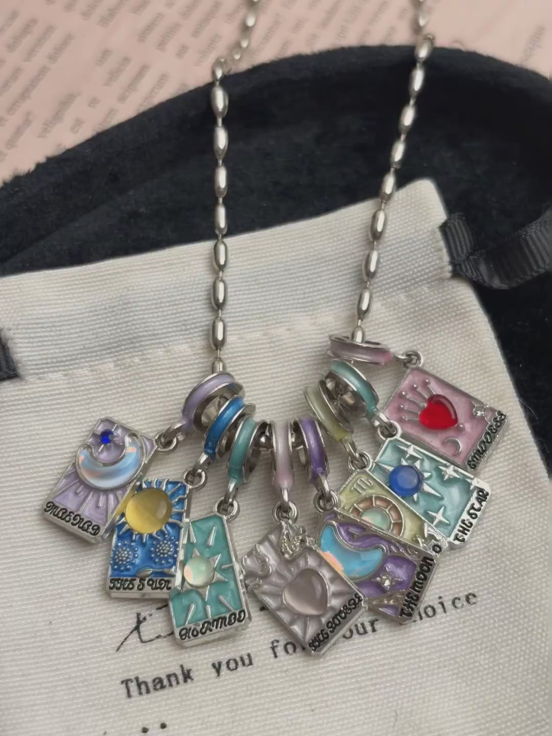 Colorful tarot-card-style necklace with moon, star, heart, and sun charms