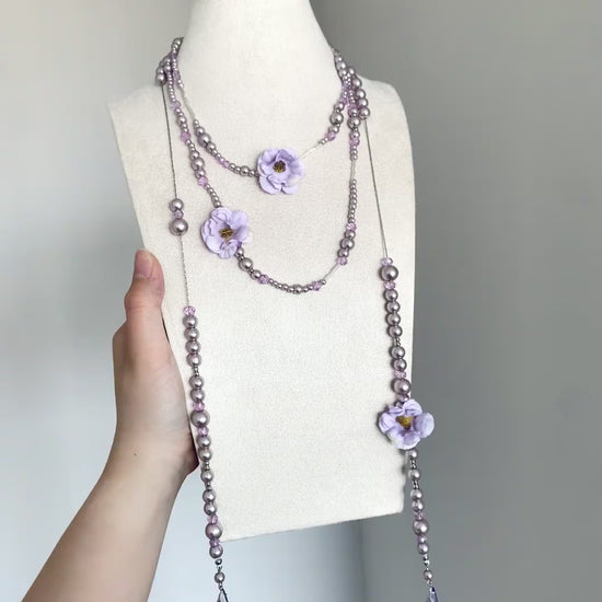Purple pearl-style necklace with flower charms and soft romantic styling