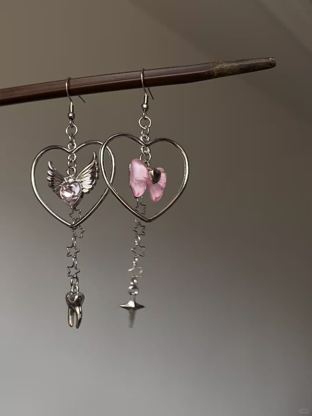 Y2K silver-tone dangle earrings with heart frame, winged heart, and star chain details
