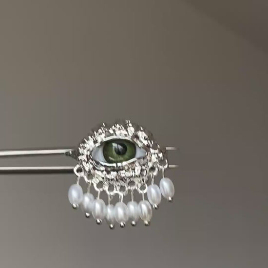 Silver-tone eye ring with green eye centerpiece and vintage textured frame
