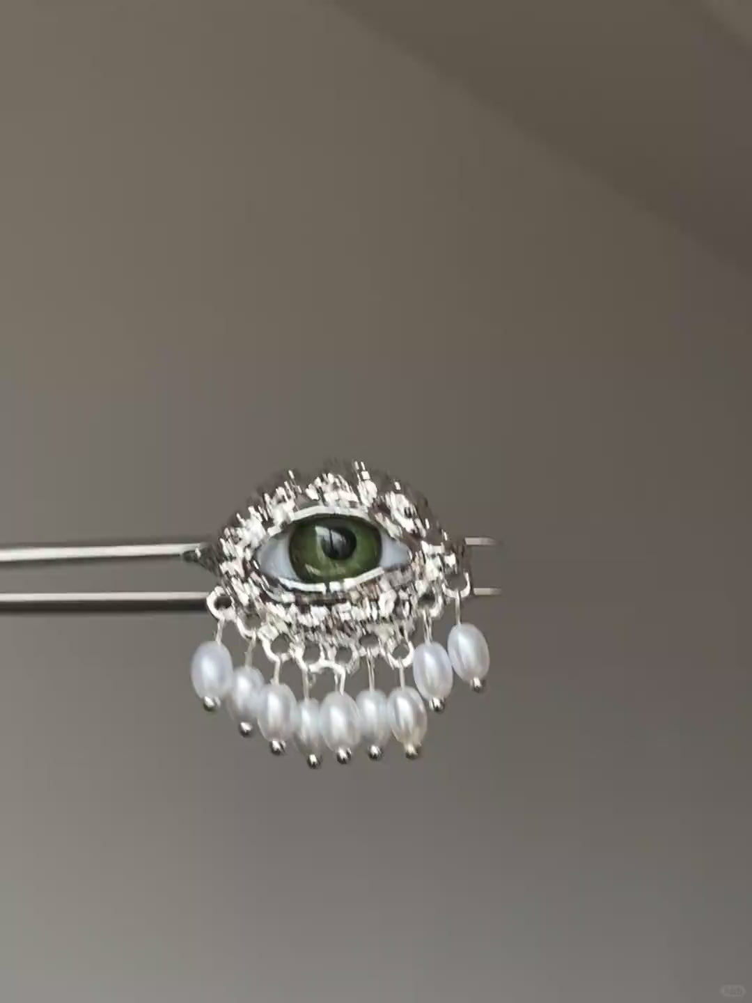 Silver-tone eye ring with green eye centerpiece and vintage textured frame