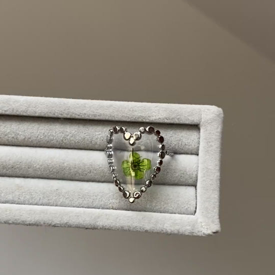 Adjustable flower ring with green bloom detail and open silver-tone band