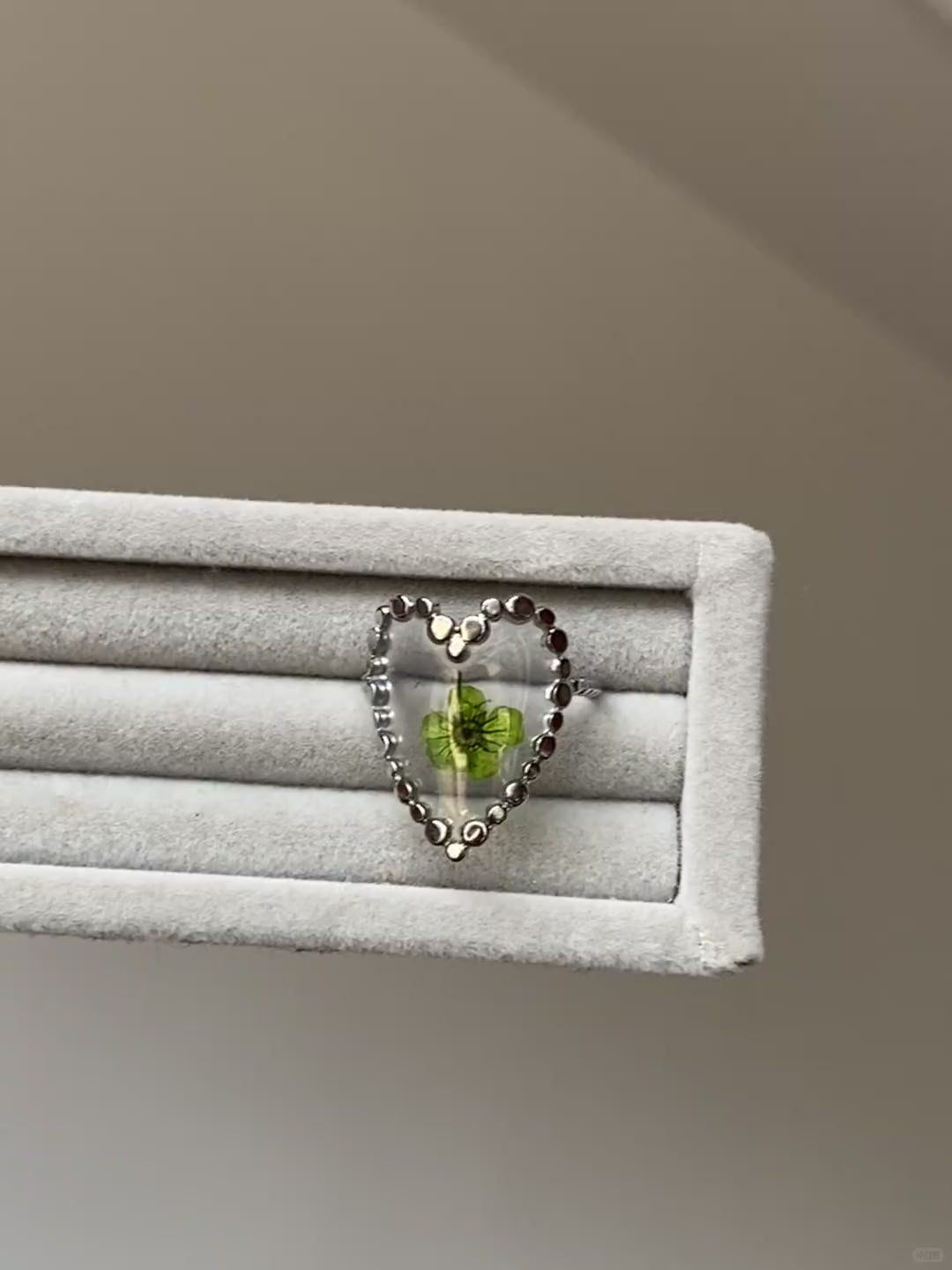 Adjustable flower ring with green bloom detail and open silver-tone band