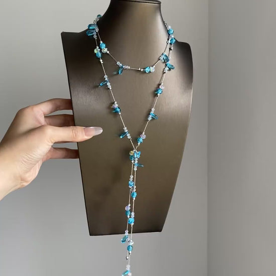 Blue rhinestone-style lariat necklace with cascading strands and dreamcore mood