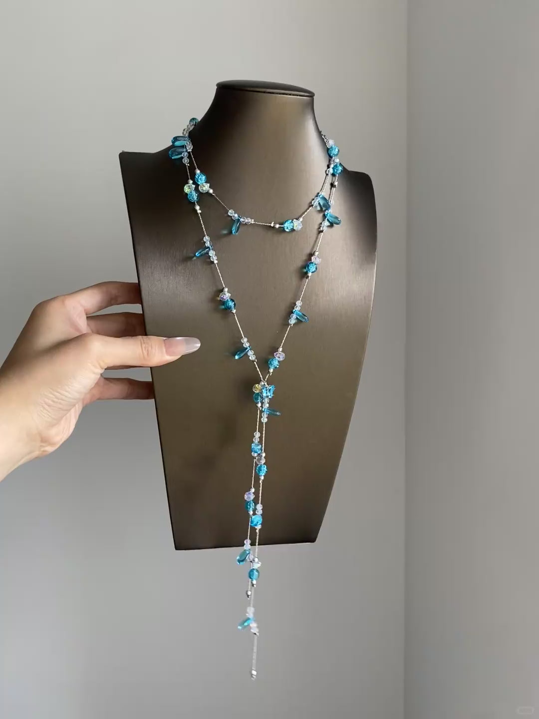 Blue rhinestone-style lariat necklace with cascading strands and dreamcore mood