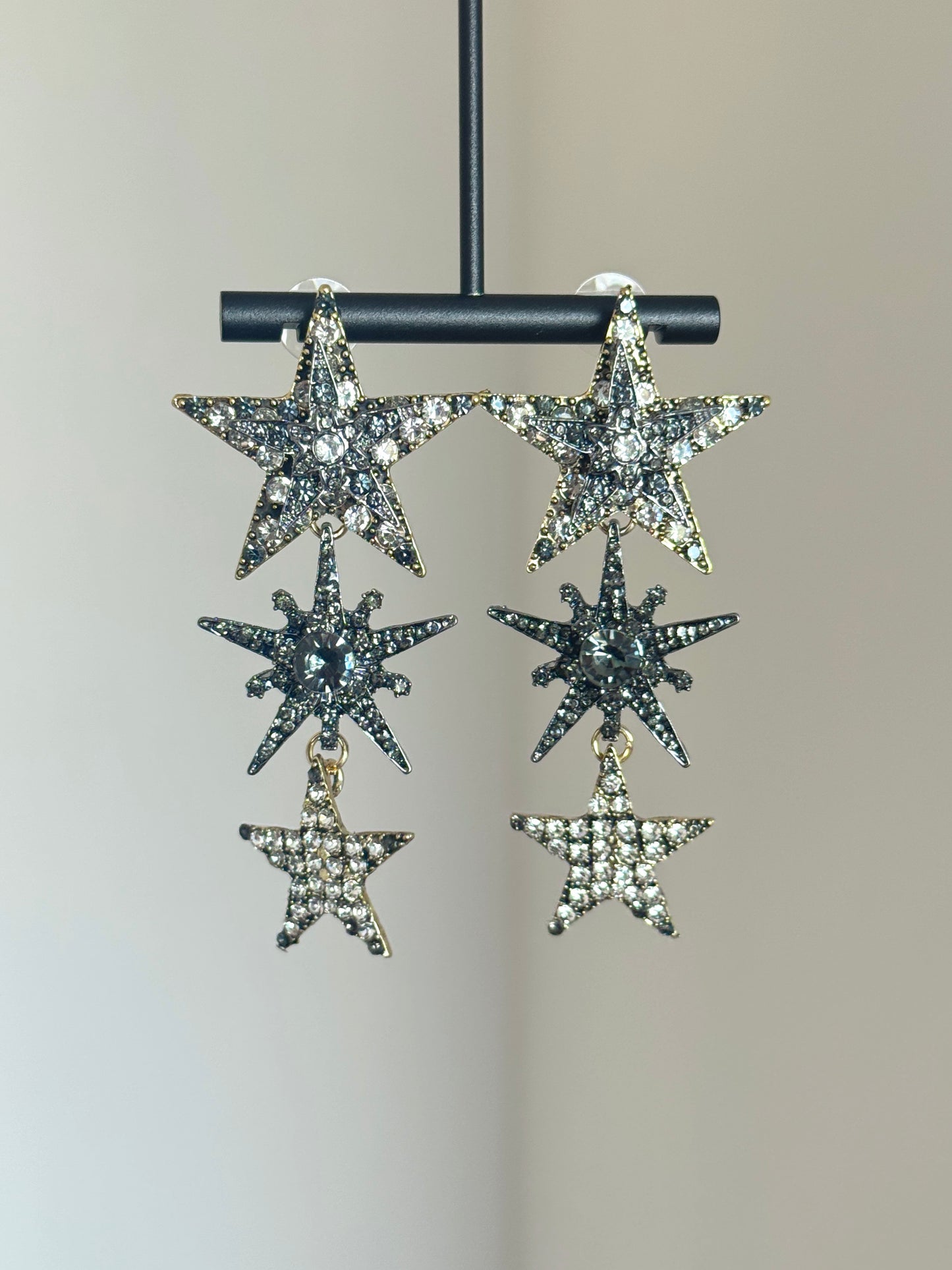 Silver-tone star earrings with sparkling rhinestone accents and long statement shape