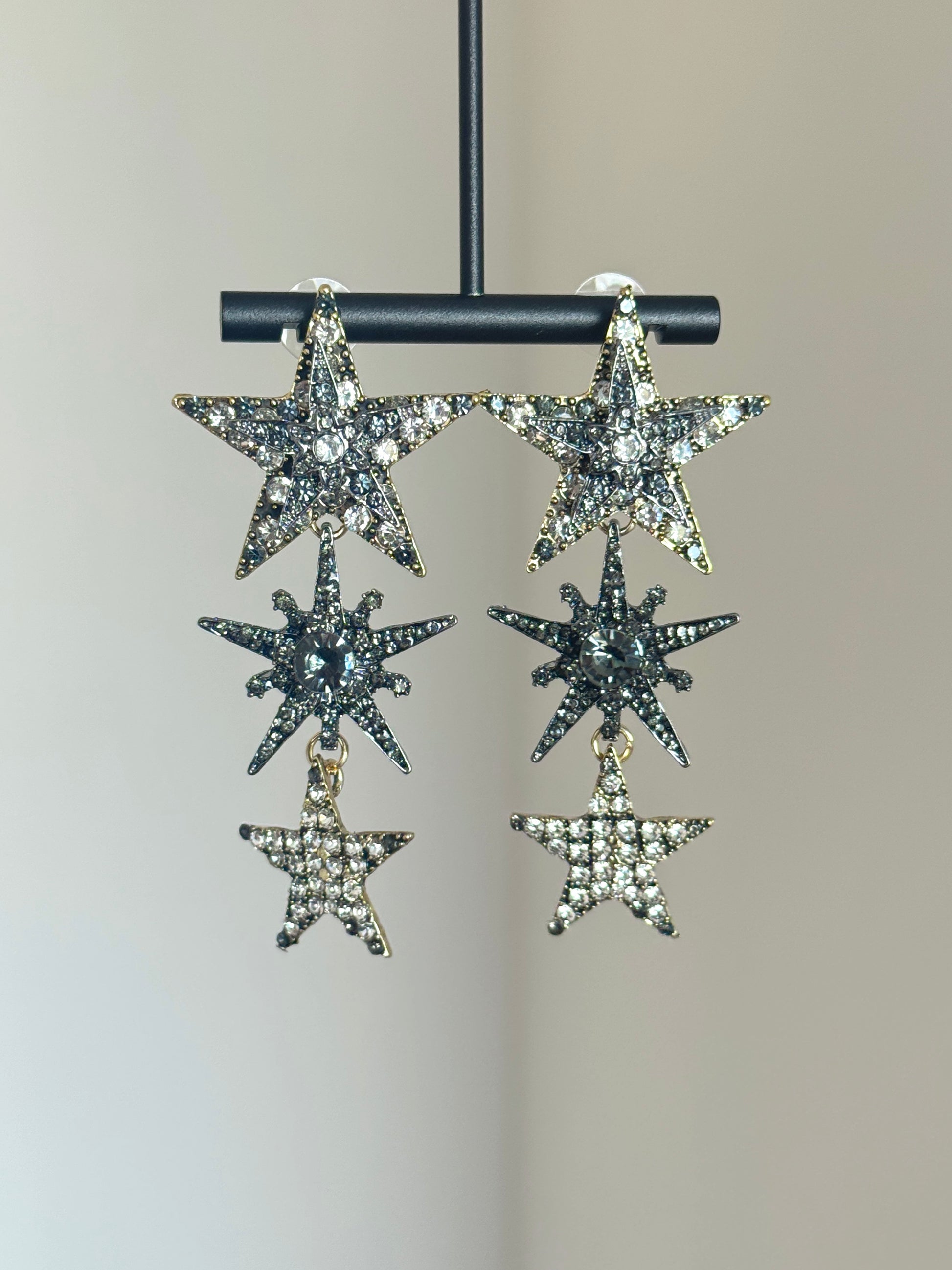 Silver-tone star earrings with sparkling rhinestone accents and long statement shape