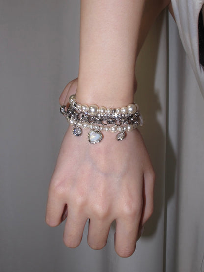 Pearl chain charm bracelet with sweet coquette mood and mixed silver-tone layers